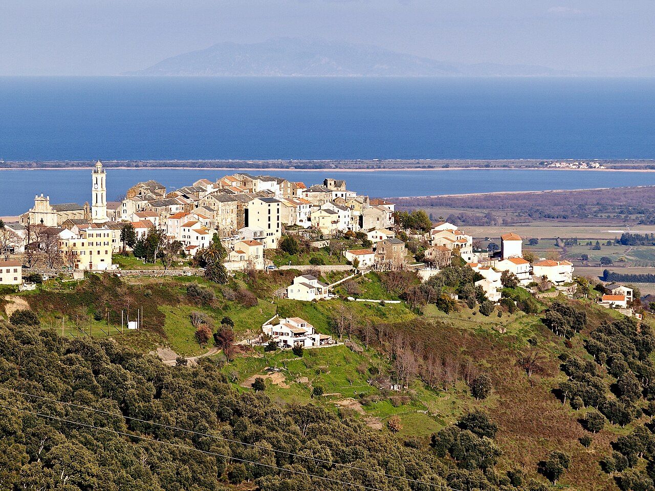 Le vieux village de Borgo sur sa crête, avec son clocher, dominant l'étang de Biguglia, la mer et, au loin, l'île d'Elbe