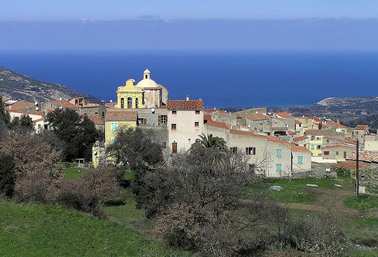 Le village de Cateri, ses maisons claires et le dôme de son église, avec la mer à l’horizon