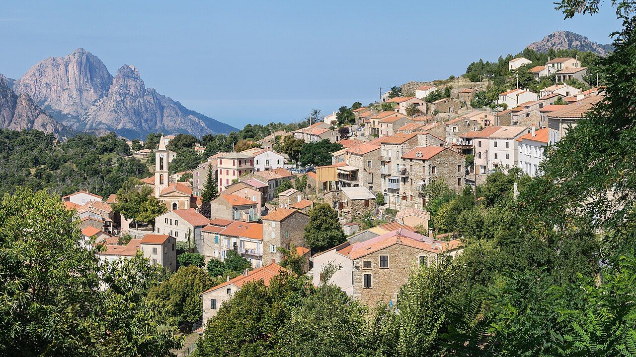 Le village d’Évisa étagé sur la pente, avec le clocher de l’église et, au fond à gauche, les sommets rocheux du Capu d’Ortu