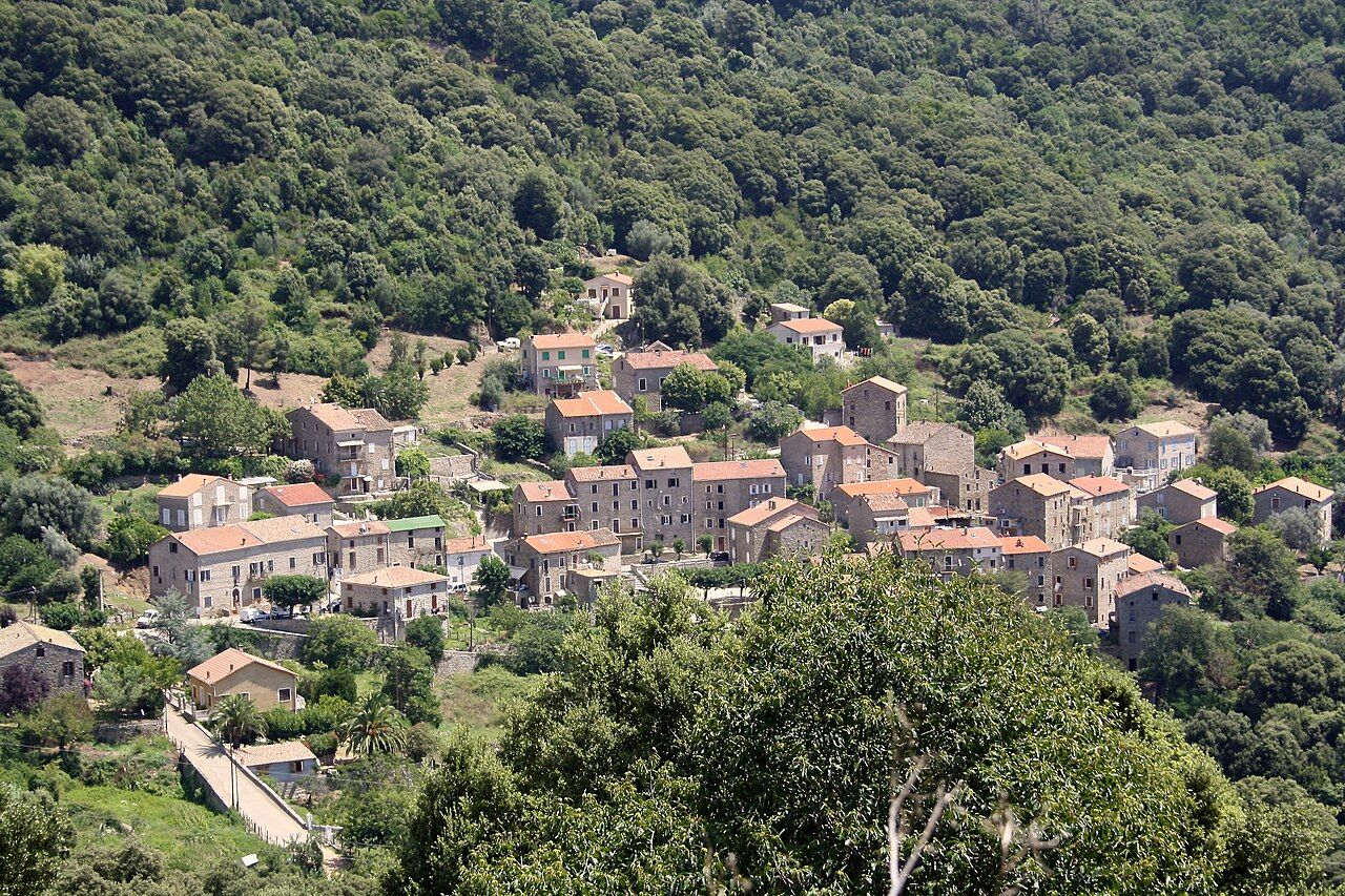 Le village de Guargualé, maisons de pierre aux toits de tuiles étagées sur un versant boisé
