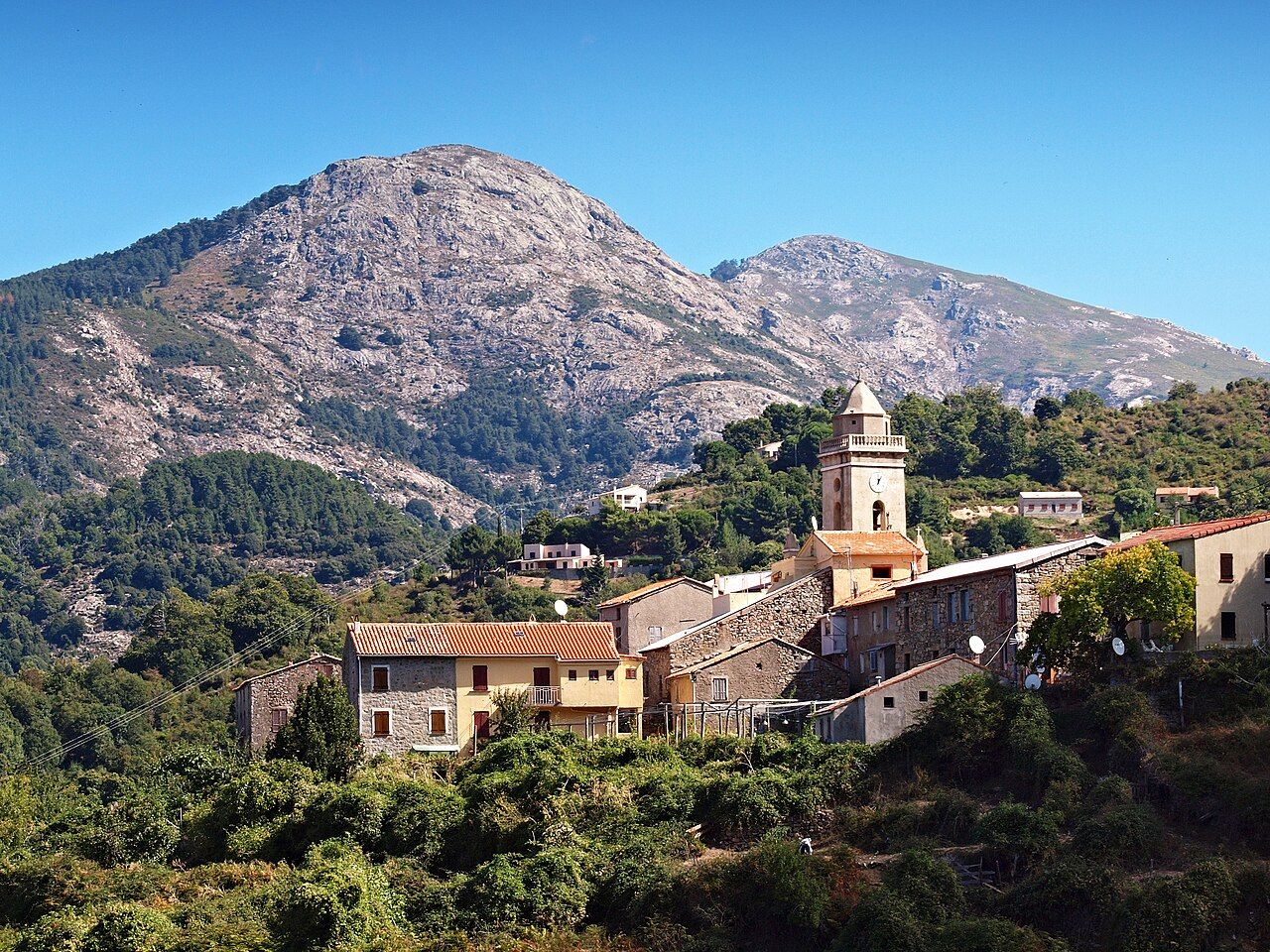 Le village de Marignana et le clocher de l’église Saint-Jacques, sur fond de montagnes granitiques et de forêts