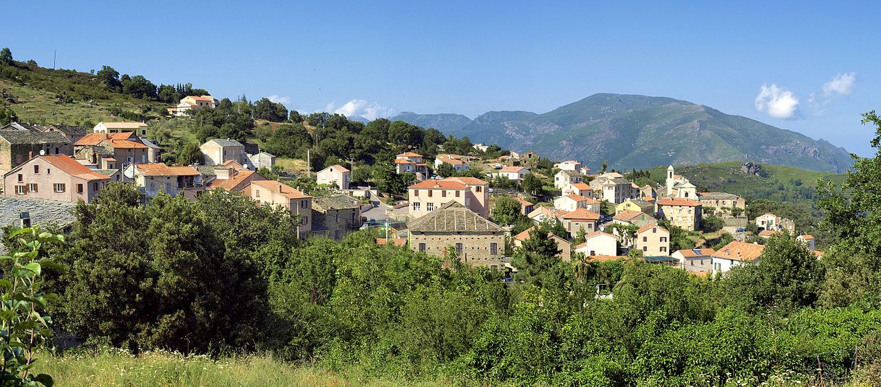 Le village de Murato, ses maisons aux toits de tuiles et de lauzes étalées sur le versant ensoleillé, devant les montagnes du Nebbiu