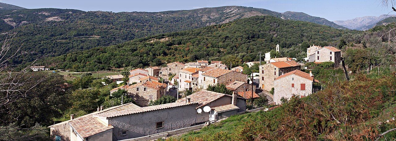 Vue panoramique du village de Murzo, maisons de pierre aux toits de tuiles entourées de collines boisées