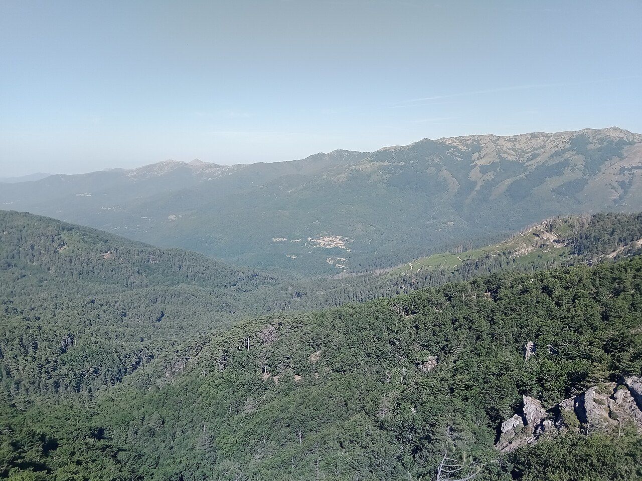 Le village de Palneca au loin, au milieu des montagnes boisées, vu depuis la Punta di Campolongo