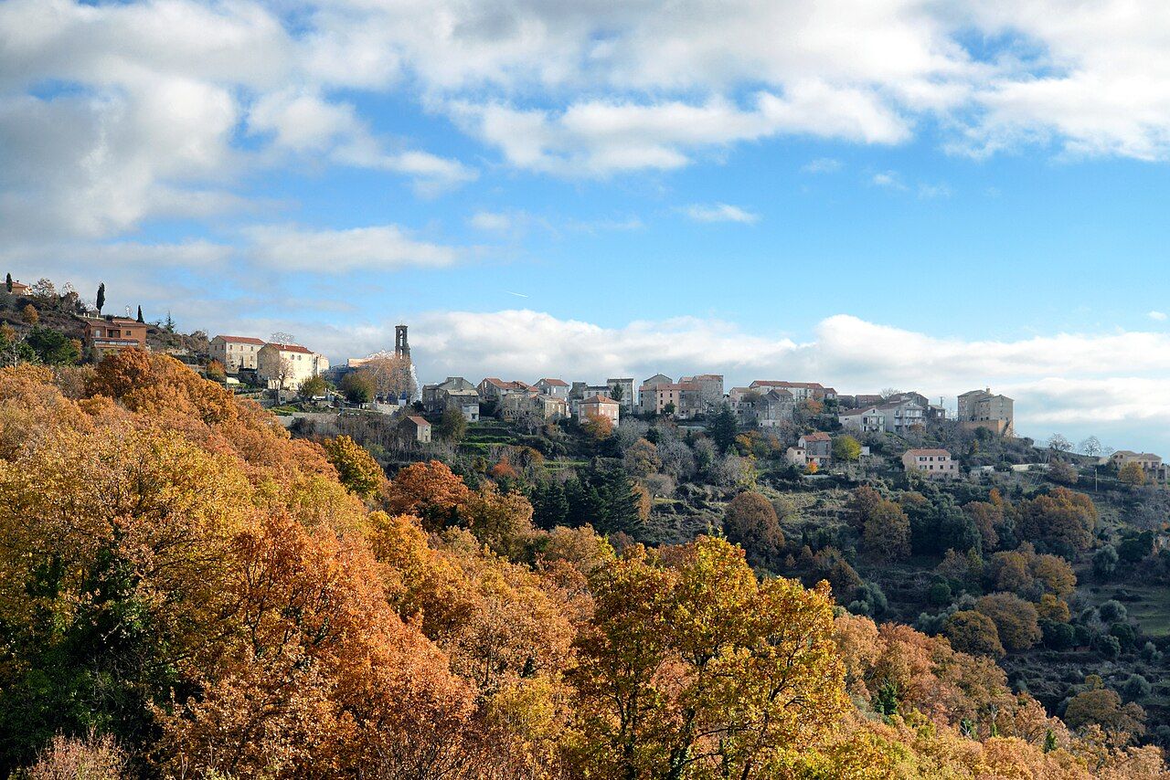 Le village de Piedicorte-di-Gaggio étiré sur sa crête, avec le clocher de l’église, au-dessus de châtaigniers aux couleurs d’automne