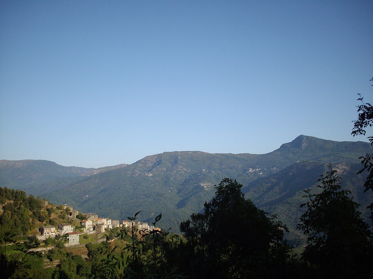 Les maisons de Pruno, en bas à gauche, devant les montagnes boisées de la Castagniccia, vues depuis les crêtes du Monte Taglio