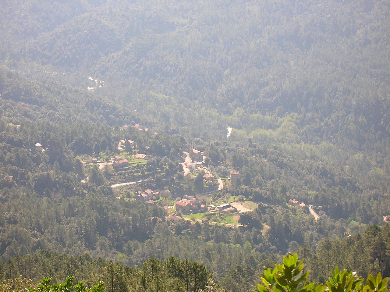 Le village de Rezza et son clocher au fond de la vallée boisée du Cruzzini, vus d’en haut depuis le sentier de la Salincaccia