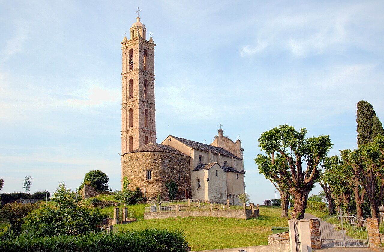 L’église San Nicolao de San-Nicolao, avec son haut clocher isolé à étages et son abside ronde, entourée d’arbres taillés