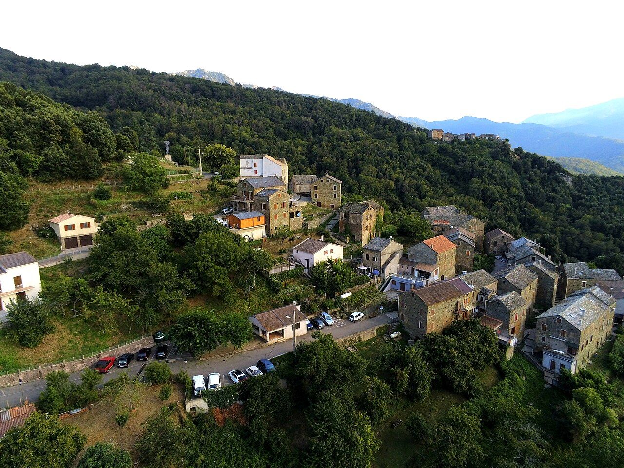 Vue aérienne du village de Scata, ses maisons de pierre le long de la route, entre les forêts de la Castagniccia