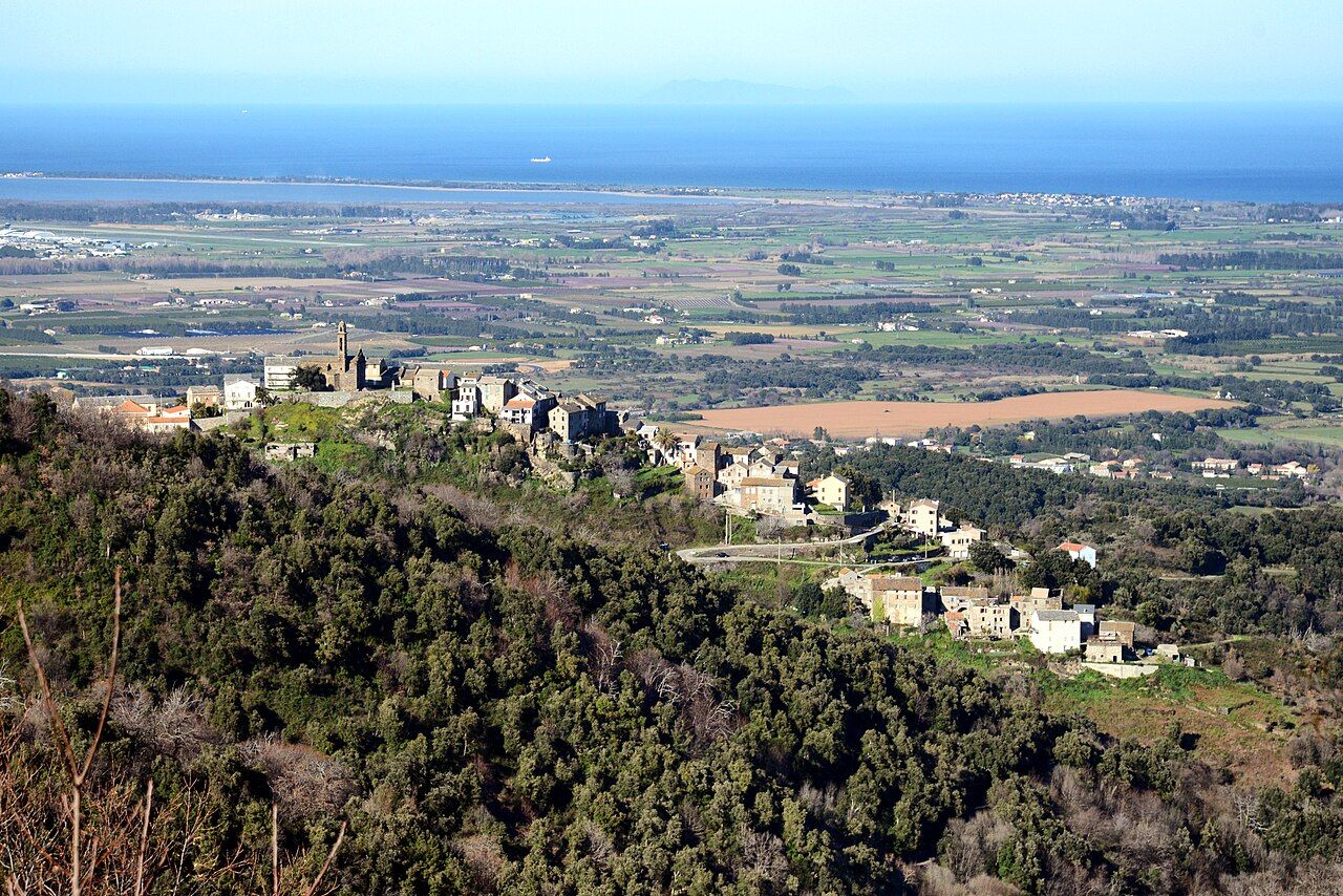 Sorbo-Ocagnano étiré à flanc de colline, vu depuis Penta-di-Casinca, au-dessus de la plaine de la Casinca et de la mer