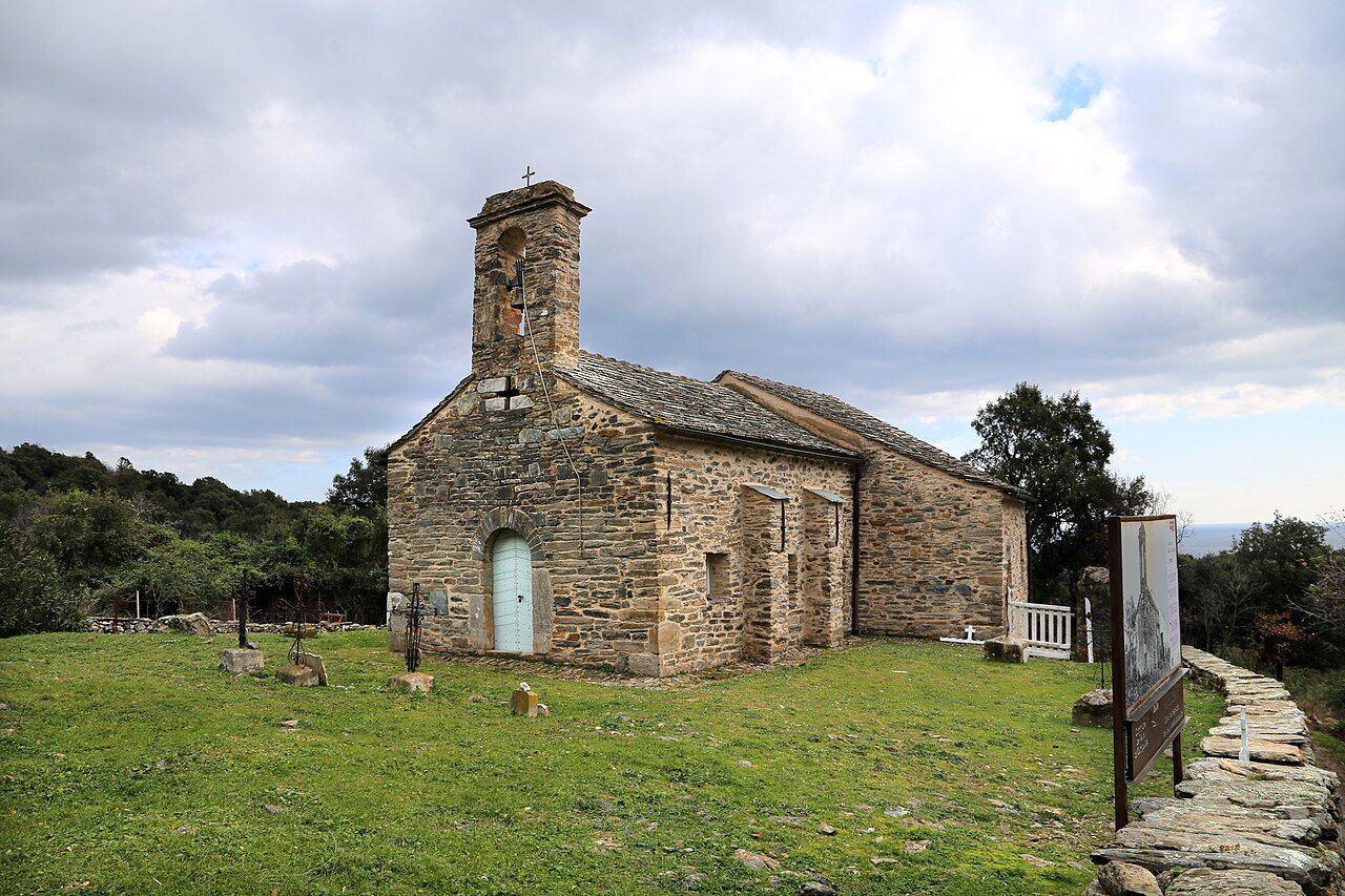 Chapelle Santa Cristina de Valle-di-Campoloro, en pierre, avec son campanile à baie unique, au milieu d’un pré